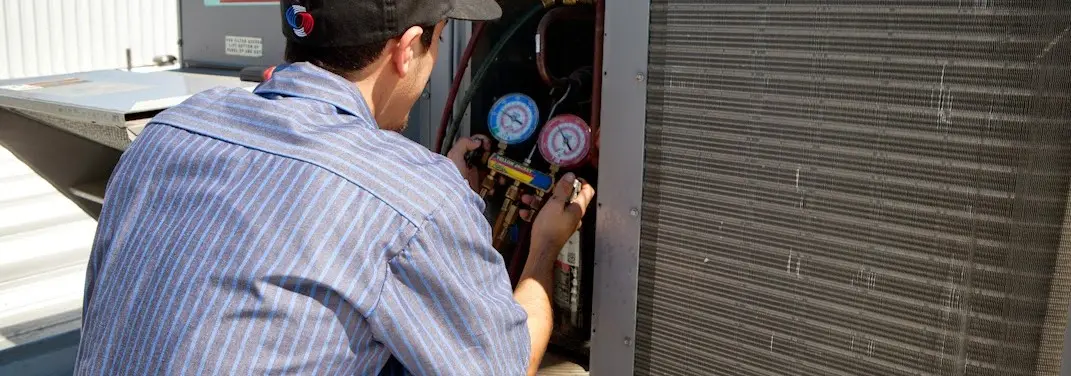 HVAC technician servicing a condenser unit in Martic
