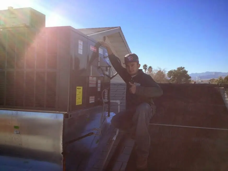 HVAC technician performing Air Duct Repair on a rooftop unit in Martic